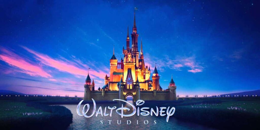 Logo de Walt Disney Studios avec château illuminé sous un ciel étoilé, représentant la magie des films Disney