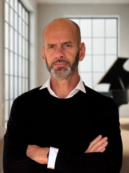 David Neyrolles, professeur de piano, devant son instrument.